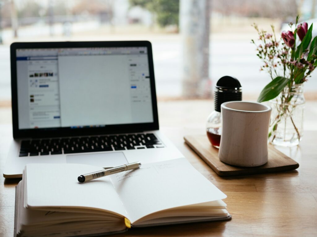 Laptop, notepad and coffee on a desk