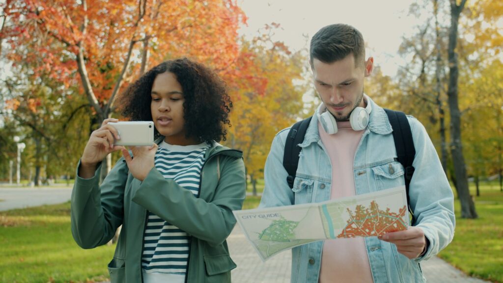 People checking a map and smartphone in the city